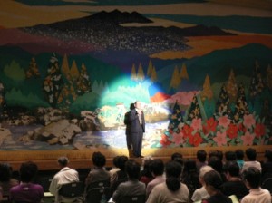 最初に主催者代表で文化協会会長のご挨拶。どん帳もとても綺麗ですね。今回のトーク＆ライブショーをとても楽しみにしていたとお話してくださいました。