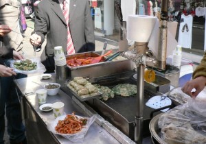 私たちはチヂミとおでんのスープ（おでんのスープは飲み放題）、そして韓国で好んで食される「スンデ」もいただき、マンドゥとキムパブ（韓国風海苔巻き）をテイクアウト。